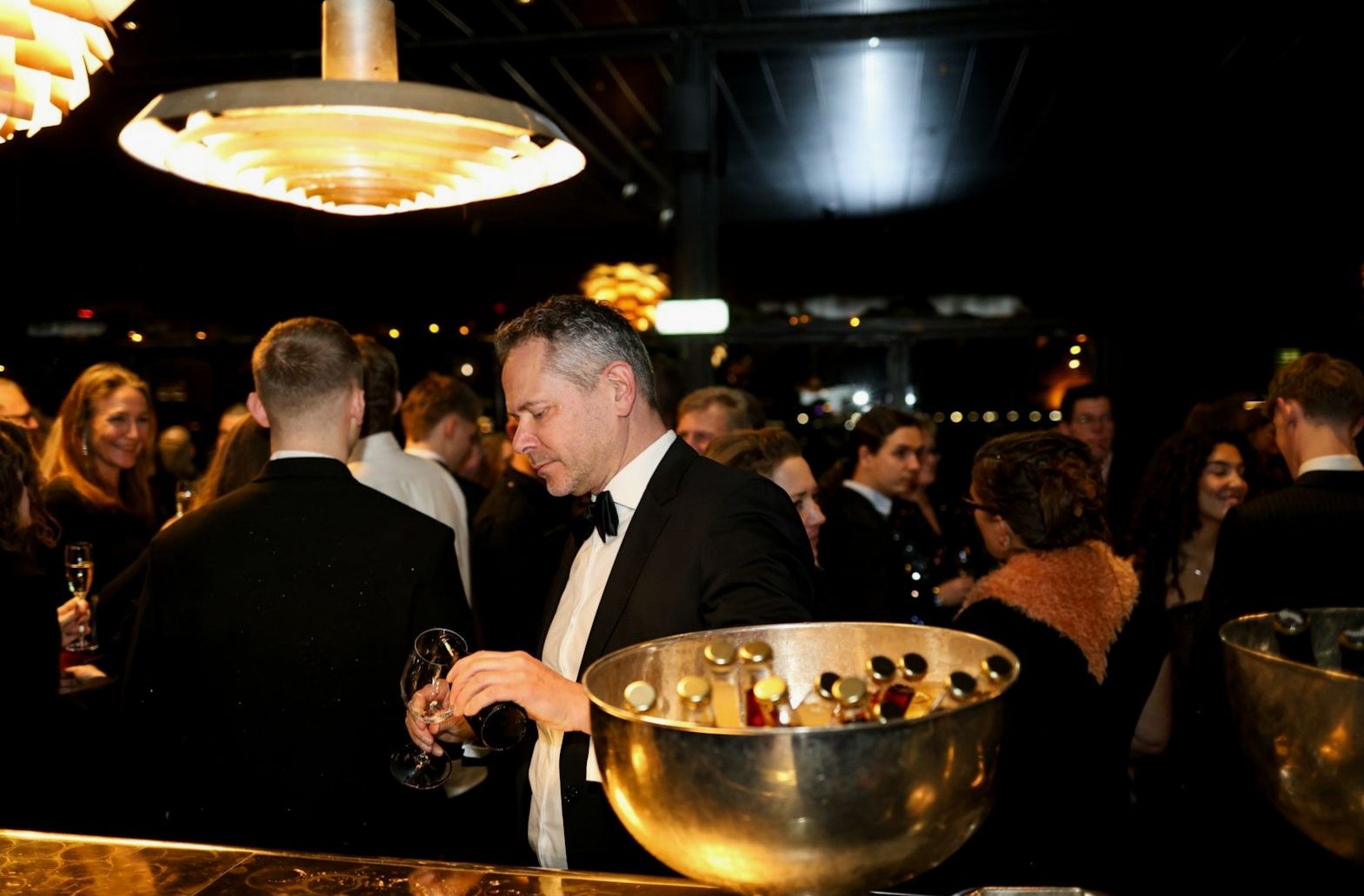 Guests in formal dress gathering in an elegant physical event venue