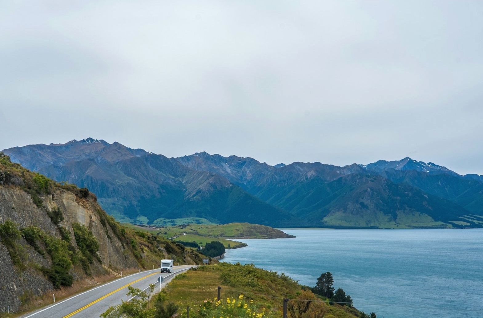 Quiet New Zealand road following the edge of a mountain lake